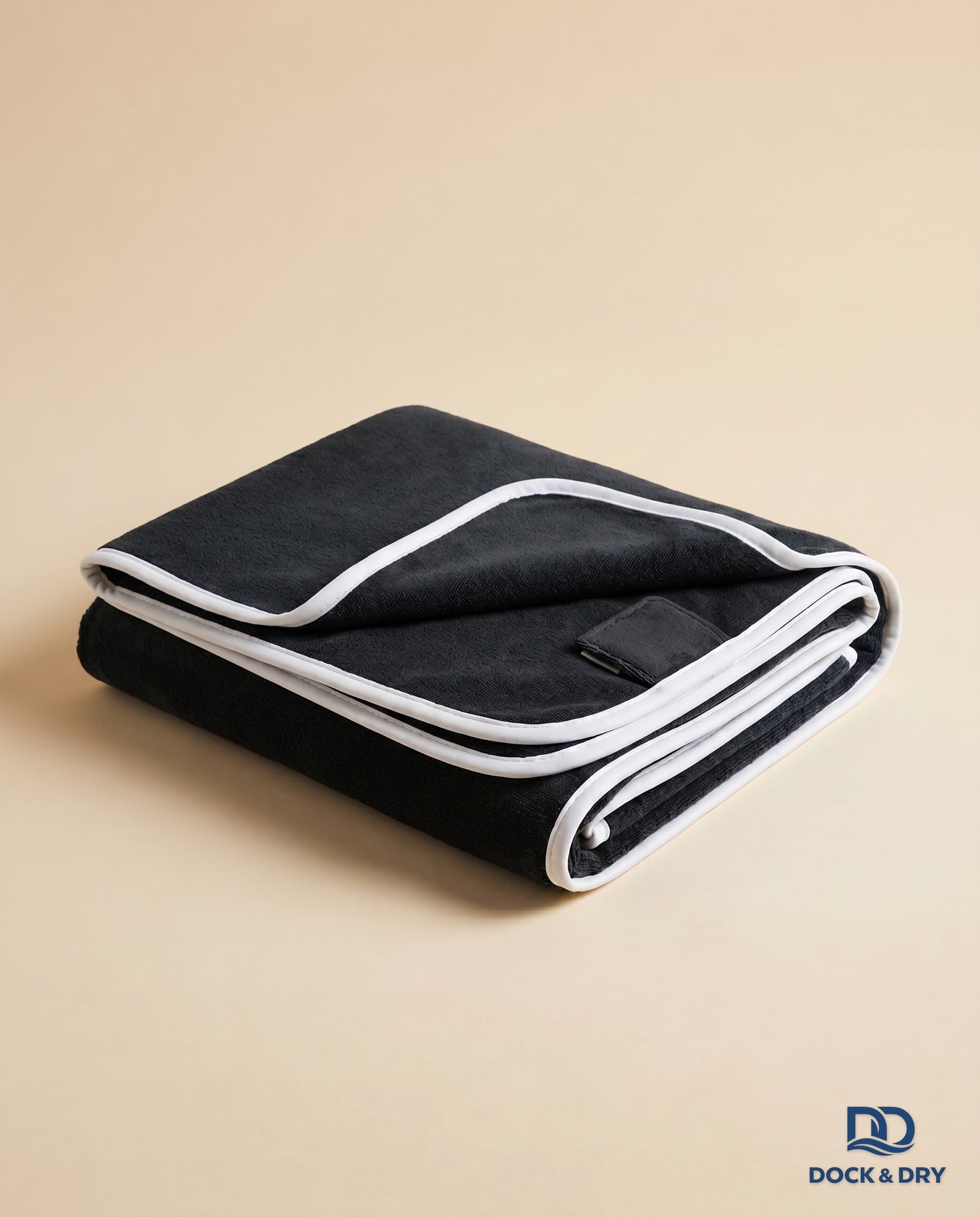 Dock & Dry magnetic beach towel – Black, folded with corner magnets