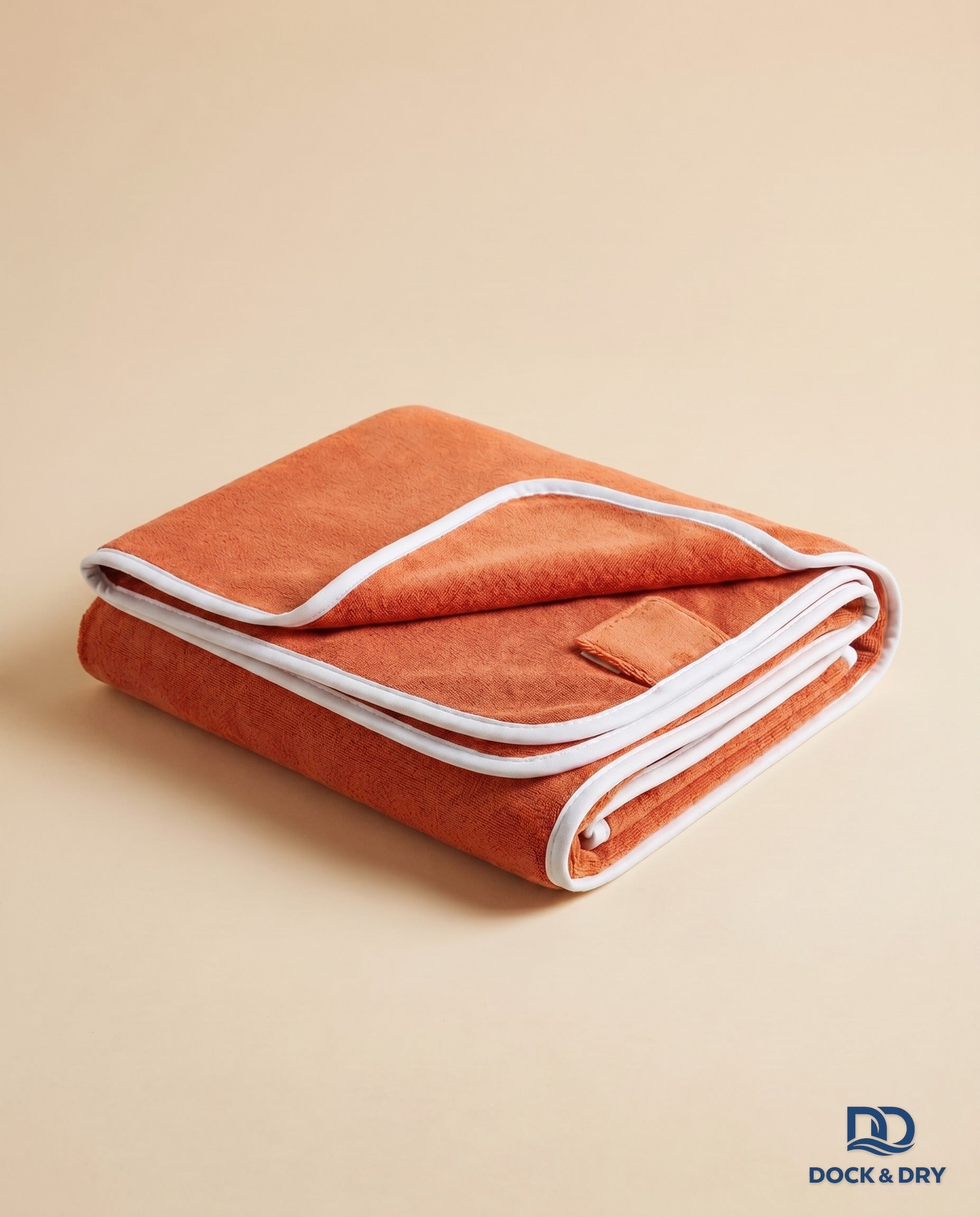 Dock & Dry magnetic beach towel – Sunset Orange, folded with corner magnets